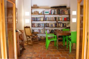 a dining room with a table and green chairs at Casa Taller El Boga in Mompós