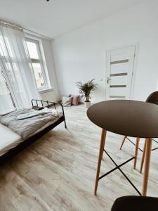 グニェズノにあるApartament w Centrumのベッドとテーブルのあるリビングルーム