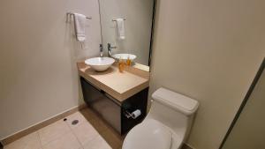 een badkamer met een wit toilet en een wastafel bij Chicago Suites WTC in Mexico-Stad
