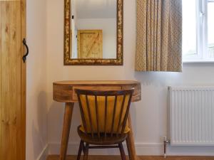a wooden table with a chair and a mirror at South Downs Lodge in Droxford
