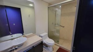 a bathroom with a toilet and a glass shower at Chicago Suites WTC in Mexico City