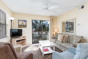 a living room with a couch and a tv at Lei Lani Village 114 in Orange Beach