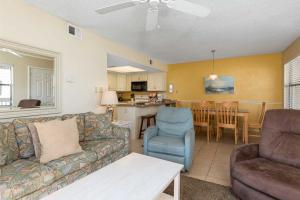 a living room with a couch and a dining room at Lei Lani Village 114 in Orange Beach