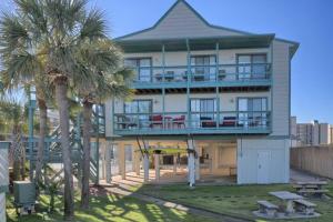 a large building with palm trees in front of it at Lei Lani Village 114 in Orange Beach