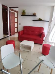 sala de estar con sofá rojo y sillas en Apartamento Reforma Ciudad de Guatemala en Guatemala