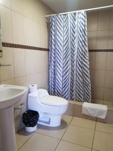 a bathroom with a toilet and a sink and a shower at Apartamento Reforma Ciudad de Guatemala in Guatemala