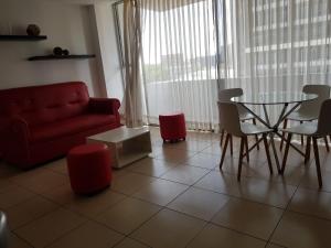 a living room with a red couch and a table and chairs at Apartamento Reforma Ciudad de Guatemala in Guatemala