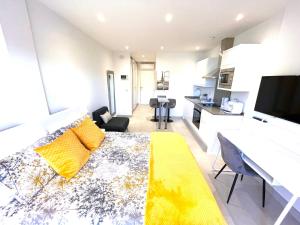a living room with a yellow couch and a kitchen at Gibraltar Central Suites in Gibraltar