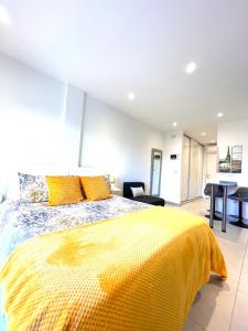 a bedroom with a bed with a yellow blanket at Gibraltar Central Suites in Gibraltar