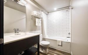 a bathroom with a sink and a toilet and a tub at Tofino Resort + Marina in Tofino