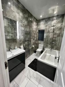 a bathroom with a sink and a tub and a toilet at Luxury Apartment in Nuneaton in Nuneaton