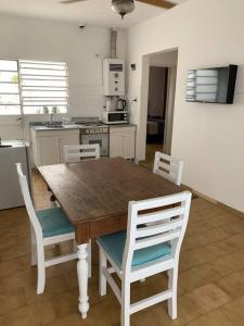 cocina con mesa de madera y sillas blancas en CASA SERENDIPIA PH interno en Alberdi en Córdoba