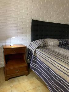 1 dormitorio con 1 cama y mesita de noche con lámpara en CASA SERENDIPIA PH interno en Alberdi en Córdoba