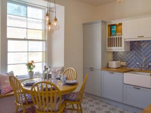a kitchen with a wooden table and chairs and a dining room at The Fishermans Loft in Cellardyke