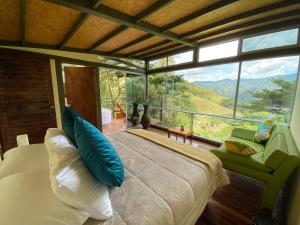 1 dormitorio con cama y ventana grande en ANCESTRAL GLAMPING, en Barbosa