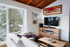 a living room with white furniture and a tv at Golf Bad Kleinkirchheim in Bad Kleinkirchheim
