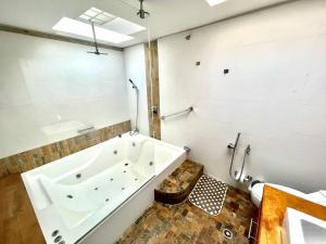 uma casa de banho com uma banheira grande e um WC. em Ámbar Hostel San Gil em San Gil
