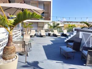 un patio con sillas, mesas y una palmera en SILVERSANDS Hotel Boutique - 5Th Ave en Playa del Carmen