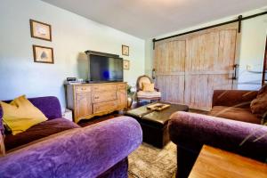 a living room with two purple couches and a tv at Red Tail Ridge PNW in Philomath