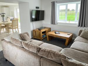 a living room with a couch and a table at Four Burrows Bungalow in Chacewater