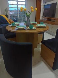a dining room table with two chairs and a television at Apartamento aconchegante 2 quartos próximo à Miguel Sutil in Cuiabá