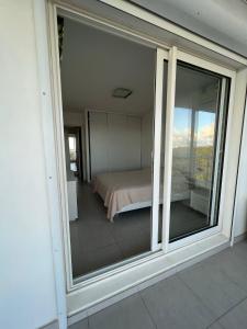 widok na sypialnię przez przesuwne szklane drzwi w obiekcie Appartement de standing vue mer w mieście Schœlcher