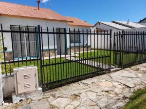 a black metal fence in front of a house at Estrella in Trevelin