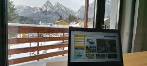 einem Laptop auf einem Schreibtisch vor einem Fenster in der Unterkunft Vila PANORAMIC Busteni in Buşteni