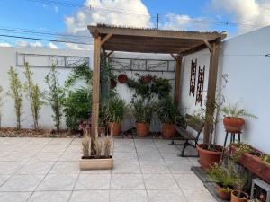 un patio con macetas y pérgola de madera en Casatempo Moradas Pelotas Quartier proximo hospital Unimed, en Pelotas