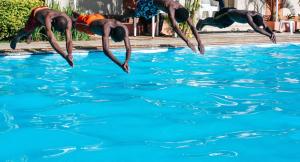 a group of people jumping into a swimming pool at keur manga in Somone