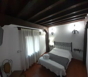 a bedroom with a large bed and a window at Hotel Rural Sierra de Francia in Sotoserrano