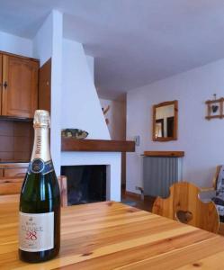 una bottiglia di vino seduta su un tavolo di legno di CASA GILDA Val di Fiemme - Dolomiti a Cavalese