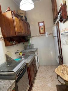 cocina pequeña con fregadero y fogones en Appartement meublé 5 personnes en plein centre ville, en Rabat