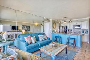 un soggiorno con divano blu e una cucina di San Luis Resort 934-Luis Landing a Galveston