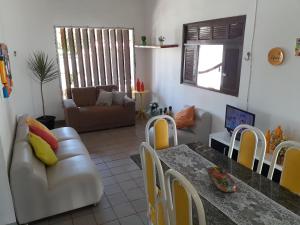 sala de estar con mesa y sofá en Casa de Praia Veraneio en Maceió