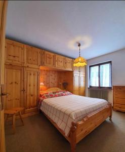 una camera con un grande letto e armadi in legno di CASA GILDA Val di Fiemme - Dolomiti a Cavalese