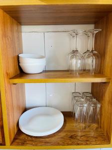 a wooden shelf with glasses and plates on it at Unique apartment in Mombasa