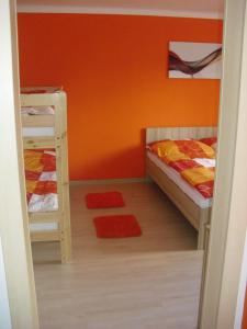 a bedroom with two bunk beds and an orange wall at Apartmán Linda in Lipno nad Vltavou