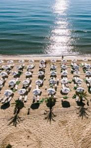 un grupo de sombrillas y sillas en una playa en Апартамент в Green Life Beach Resort Sozopol, en Sozopol