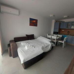 ein Schlafzimmer mit einem großen Bett, einem Tisch und Stühlen in der Unterkunft Апартамент в Green Life Beach Resort Sozopol in Sozopol