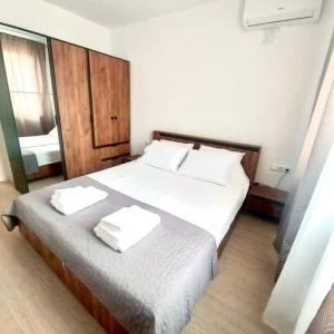 a bedroom with a bed with two towels on it at Апартамент в Green Life Beach Resort Sozopol in Sozopol