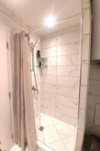 La salle de bains est pourvue d'une douche avec rideau de douche. dans l'établissement Апартамент в Green Life Beach Resort Sozopol, à Sozopol