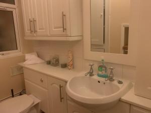 a white bathroom with a sink and a toilet at 22B in Wellingborough