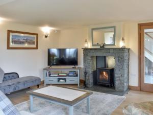 a living room with a tv and a fireplace at Stallion Barn in Crosby Garrett