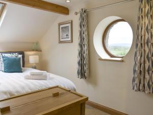 a bedroom with a bed and a window at Stallion Barn in Crosby Garrett
