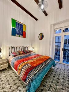 um quarto com uma cama com um edredão colorido em Puerta Roja 3 bedroom Luxury Apartment em Málaga