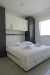 a bedroom with a large white bed with white cabinets at Villa Omazic in Trogir +44 photos