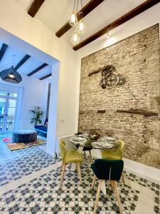 馬拉加的住宿－Puerta Roja 3 bedroom Luxury Apartment，一间设有砖墙和桌椅的用餐室