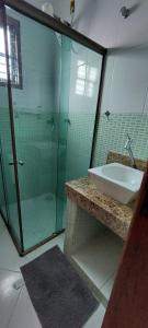 a bathroom with a sink and a glass shower at Brisa de Rio das Ostras com Wi-fi in Rio das Ostras