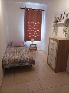 1 dormitorio con 1 cama, vestidor y ventana en Las Brisas, en Granadilla de Abona